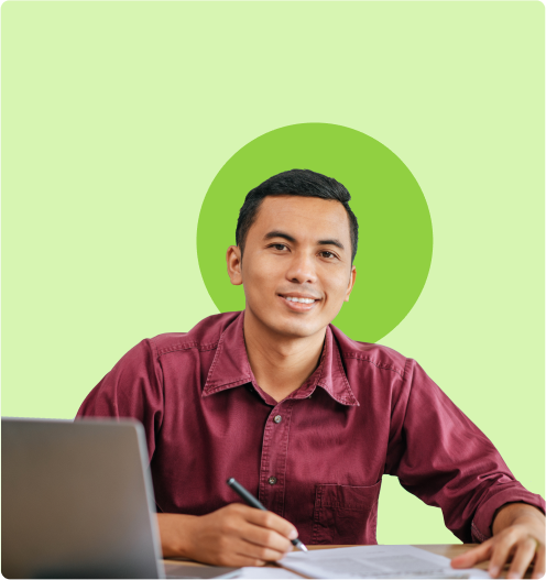 an instructor in front of a laptop, writing something